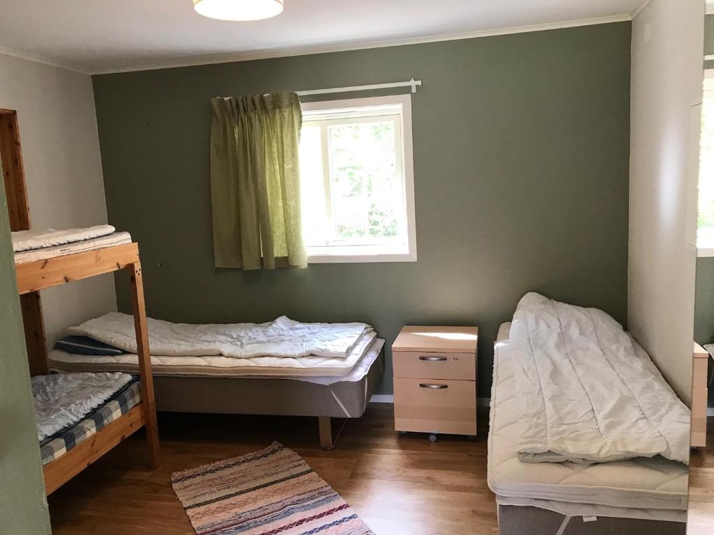 Postel nebo postele na pokoji v ubytování Sandvikengården Stugby