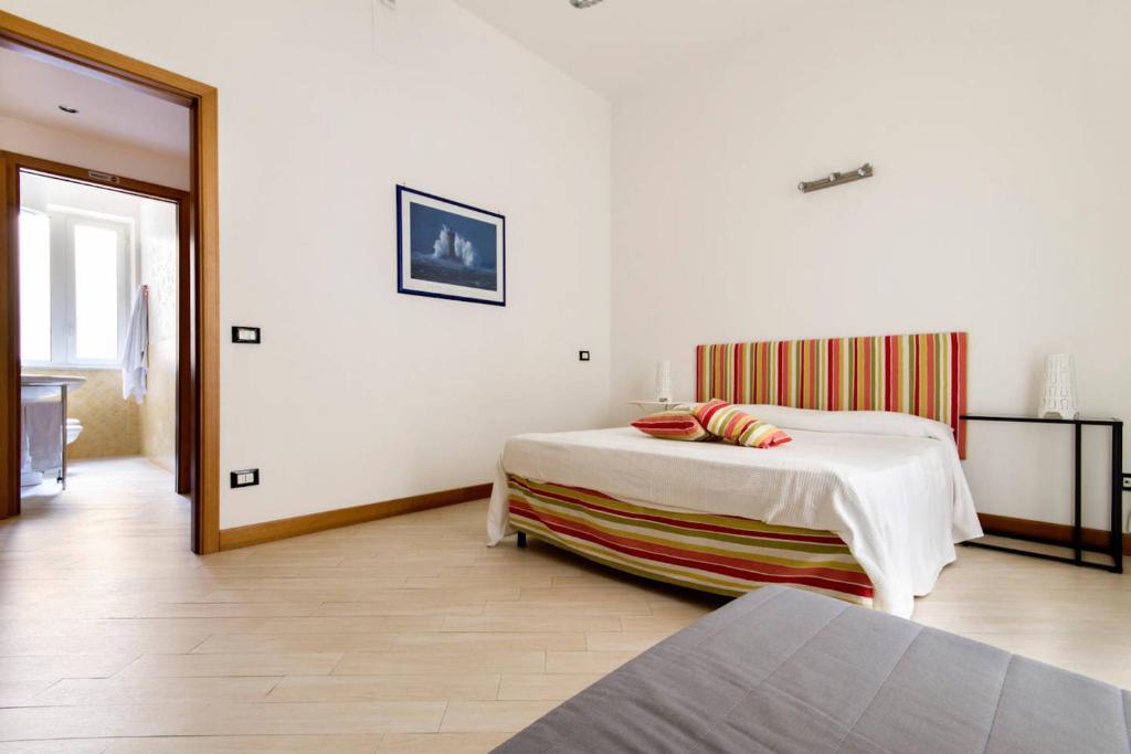 Habitación blanca con cama y espejo en Sofia's House en Palermo
