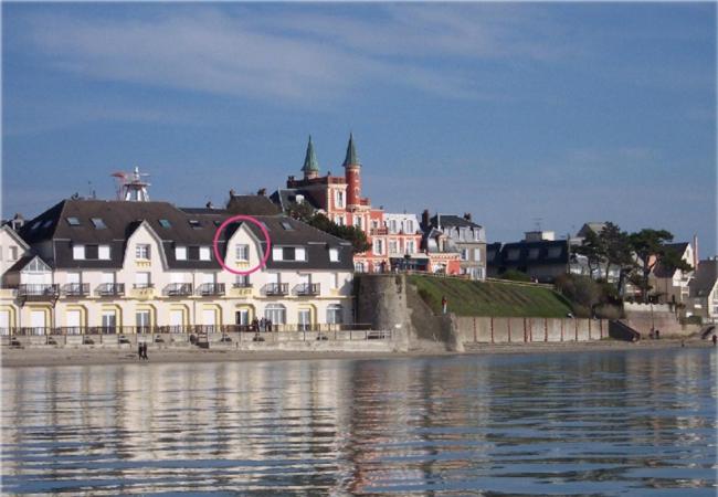 a large building on the shore of a body of water at La Caravelle en Baie in Le Crotoy