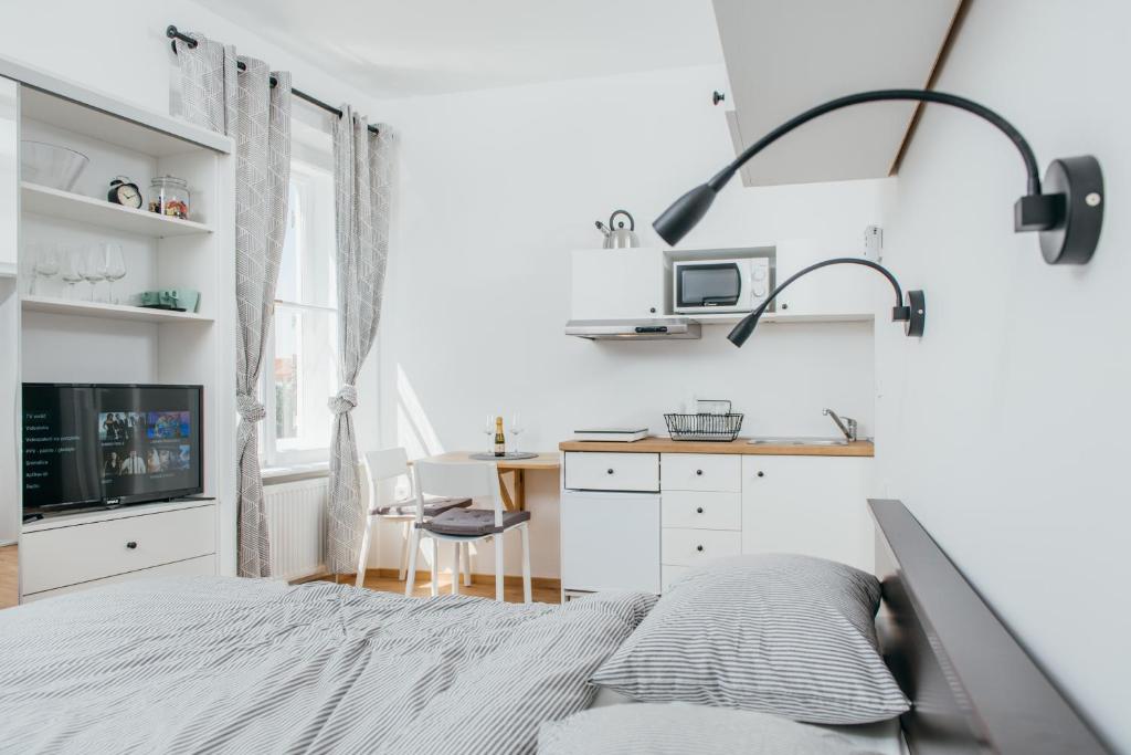 a white bedroom with a bed and a desk at Old Town Tale in Zagreb