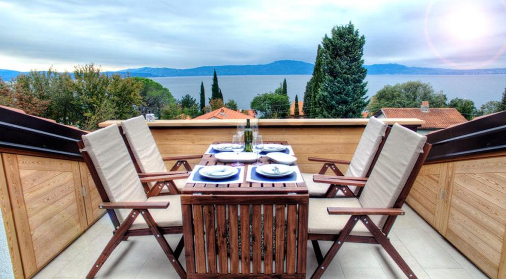 eine Terrasse mit einem Tisch und Stühlen auf dem Balkon in der Unterkunft Apartments Petra in Njivice