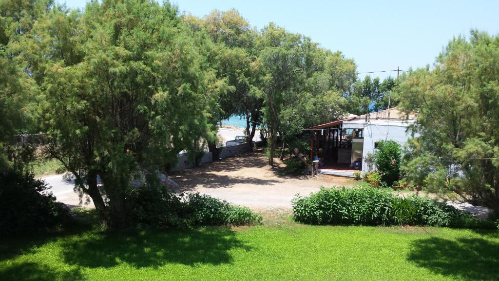 vistas a un patio con árboles y una casa en Rooms Leonidas, en Kissamos