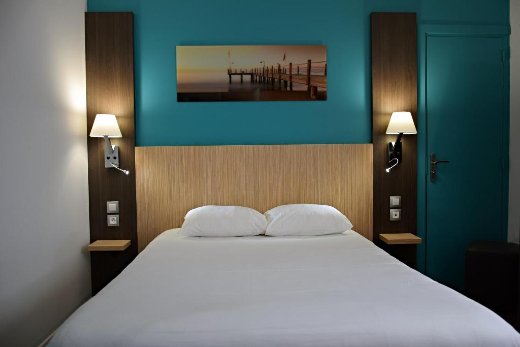 um quarto com uma cama branca e uma parede azul em Contact Hotel Le Seino Marin - Cléon Elbeuf em Cléon