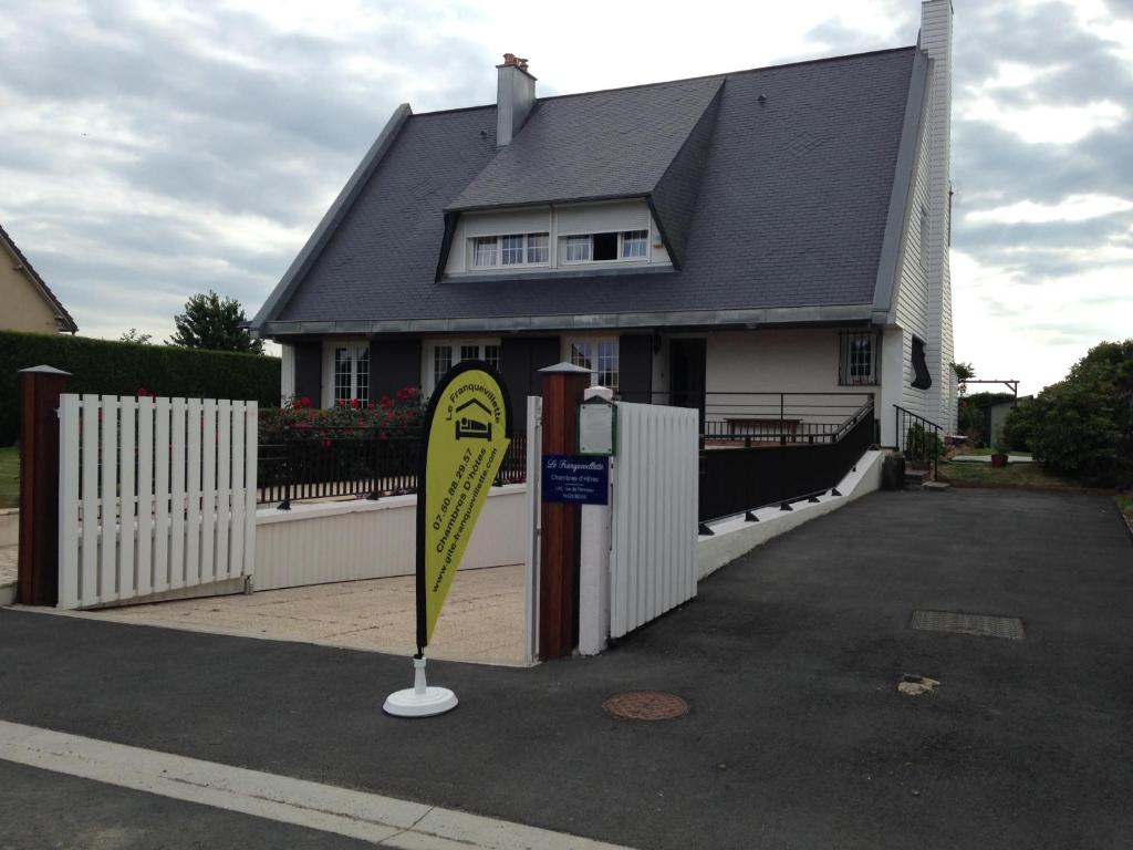 une maison avec un panneau jaune devant elle dans l'établissement Le Franquevillette, à Boos