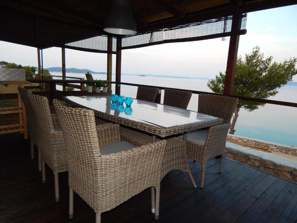 a table and chairs on a deck with a view of the ocean at Mobile House on Drage Beach in Pakoštane