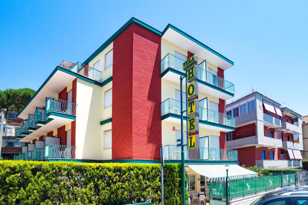 ein rot-weißes Gebäude mit einem Schild darauf in der Unterkunft Hotel Viola in Gaeta