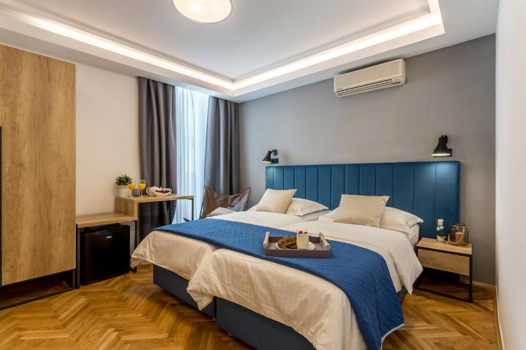 a bedroom with a large bed with a blue headboard at Central Rooms Split in Split