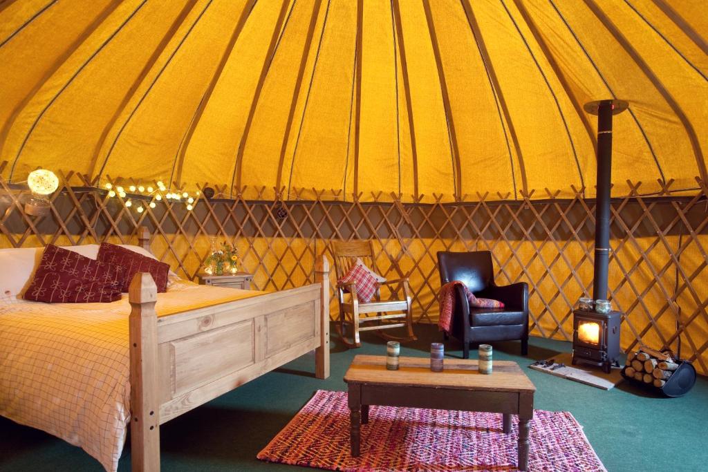 a bedroom with a bed and a stove in a yurt at Portsalon Luxury Camping in Portsalon
