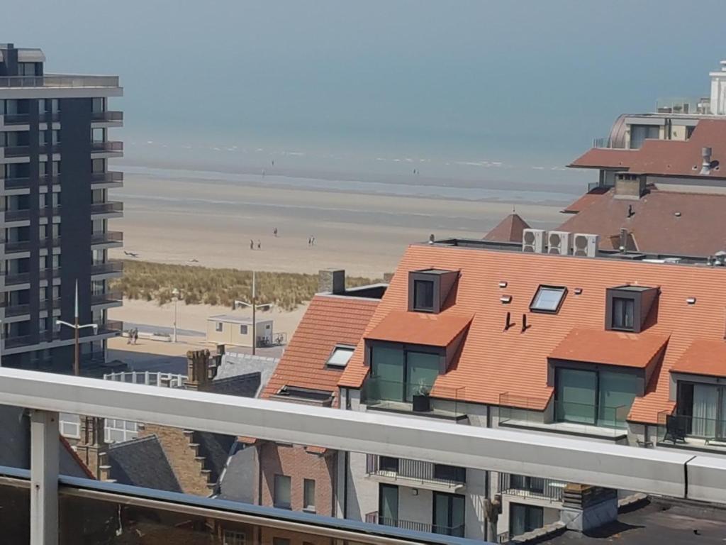 a view of the beach from the balcony of a building at Le 1003 in Nieuwpoort