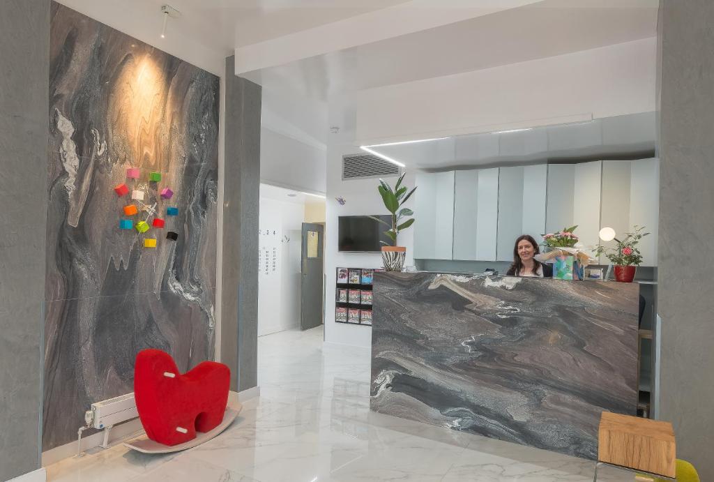 una mujer en una habitación con un sillón rojo en Victoria Inn London, en Londres