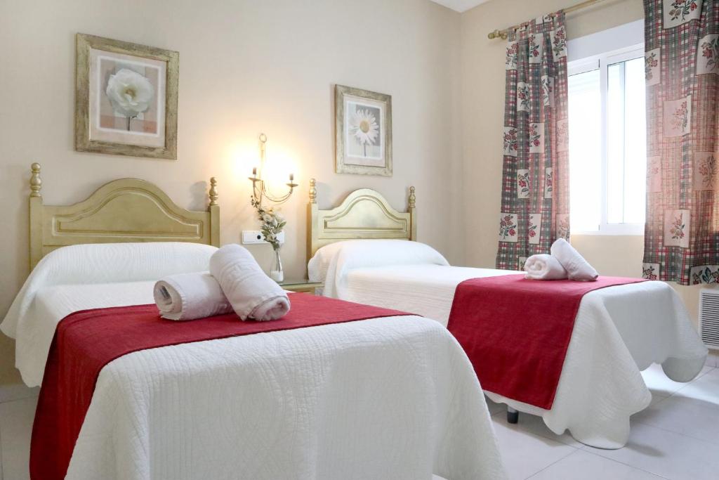 Łóżko lub łóżka w pokoju w obiekcie Hostal Victoria