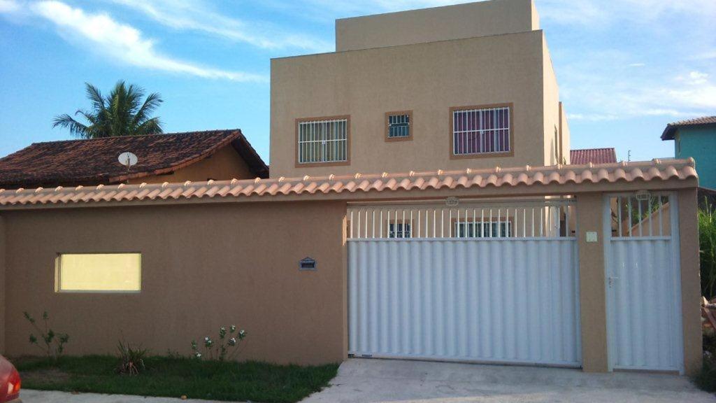 a house with a white garage door in front of it at Apto Térreo - Rio das Ostras in Rio das Ostras