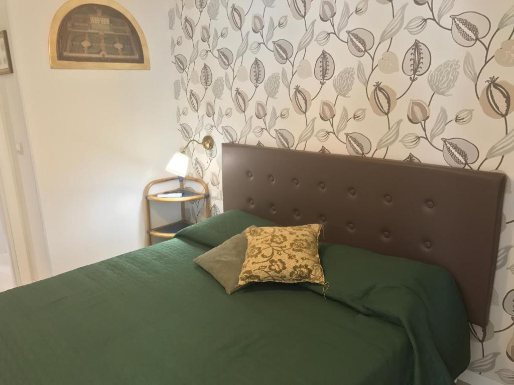a green bed with a pillow on top of it at Aquila house in Catania