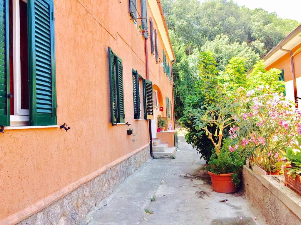 un vicolo con un edificio e alcune piante e fiori di Casa Lividonia a Porto Santo Stefano