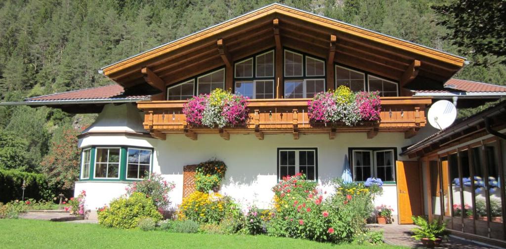 una casa con un balcón con flores. en Ferienwohnungen Drexel, en Elbigenalp