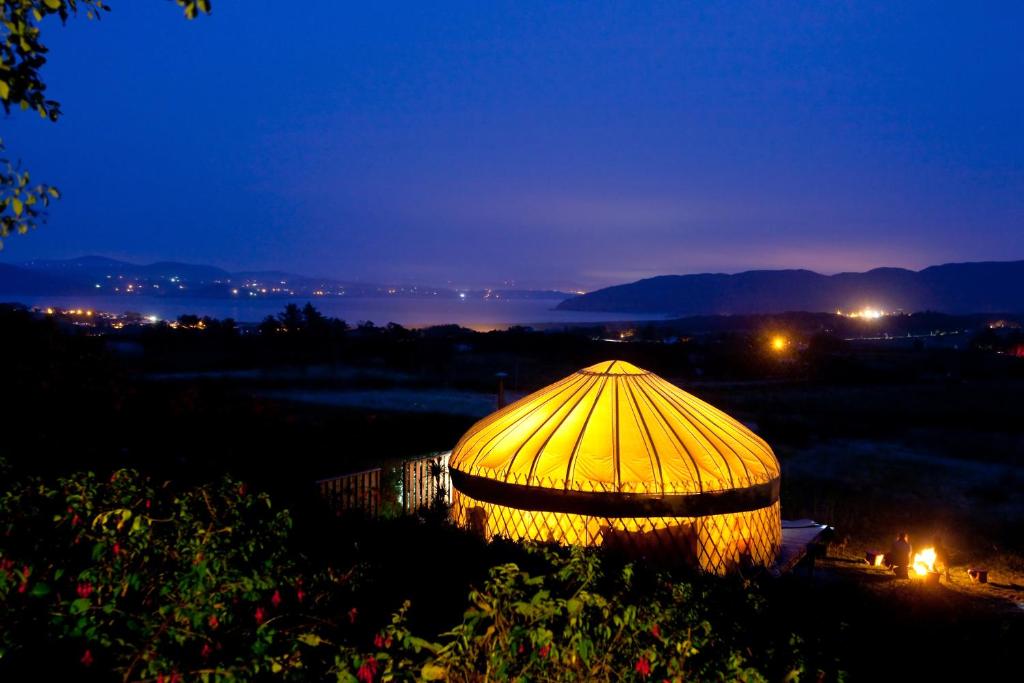 a lit up tent in a field at night at Portsalon Luxury Camping in Portsalon