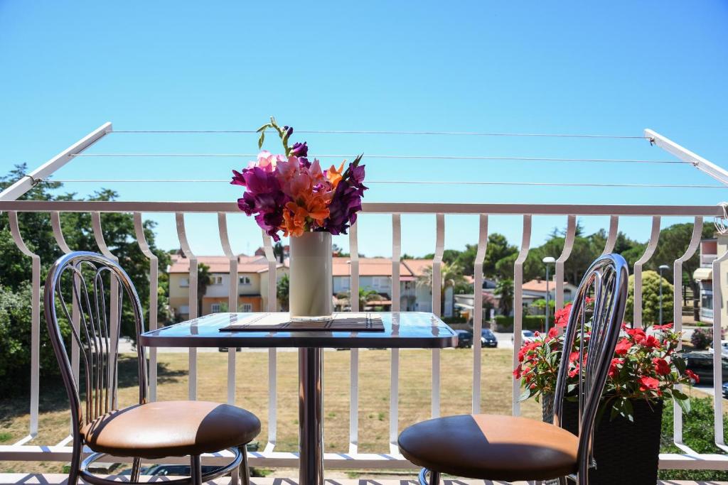 - une table avec un vase de fleurs sur le balcon dans l'établissement Duska, à Umag