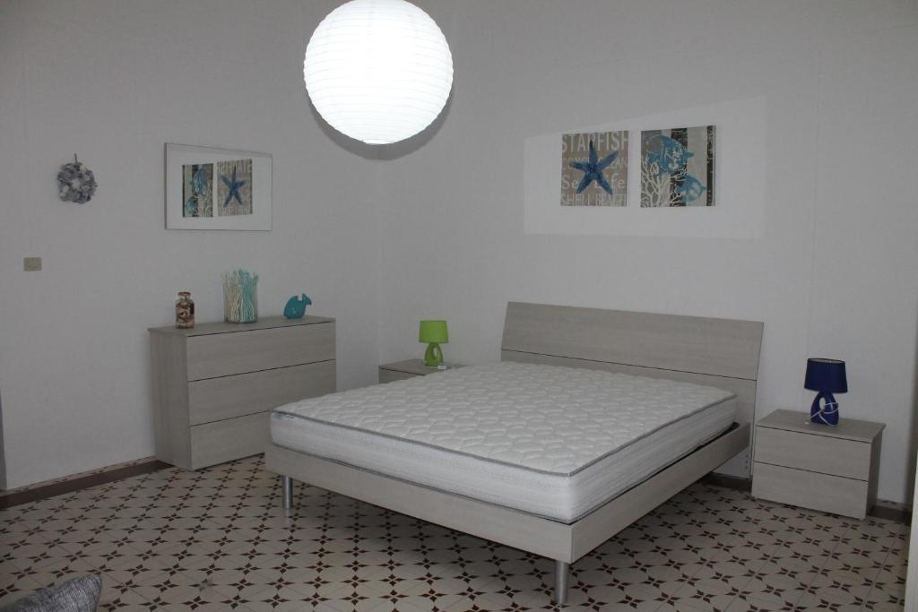 ポルト・チェザーレオにあるMasseria Pittuini Salentoの白いベッドルーム(ベッド1台、ナイトスタンド2台付)