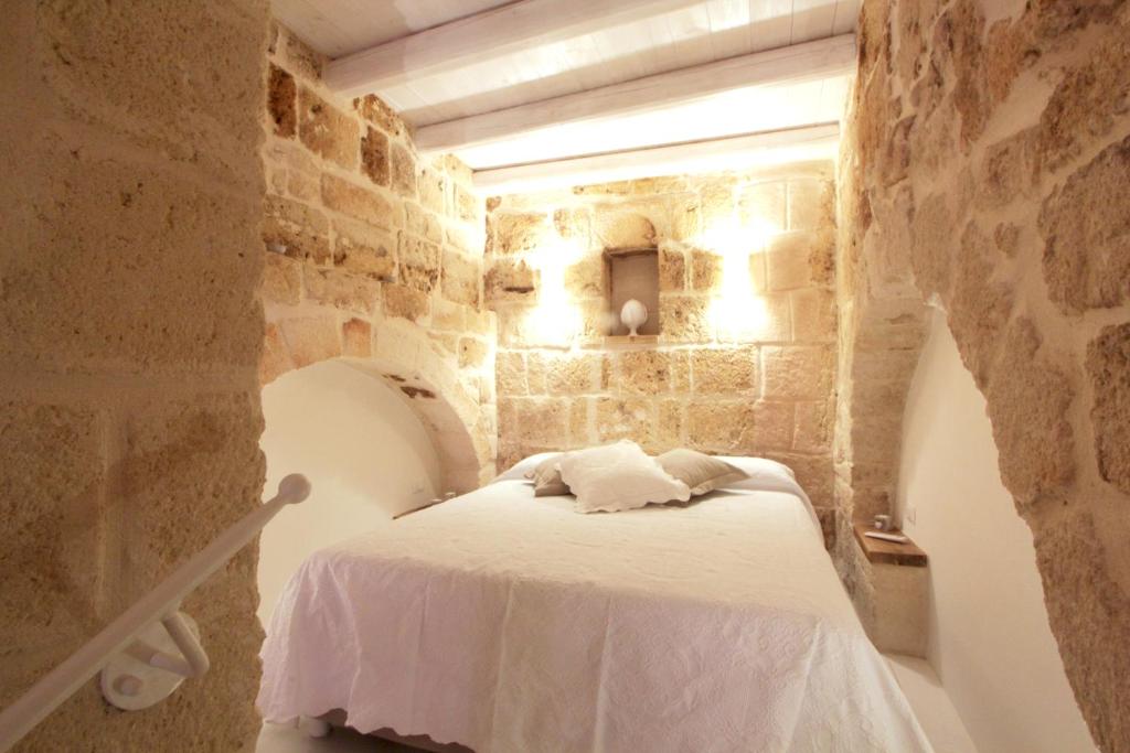 una camera con un letto in una parete in pietra di La dimora dei nonni a Monopoli