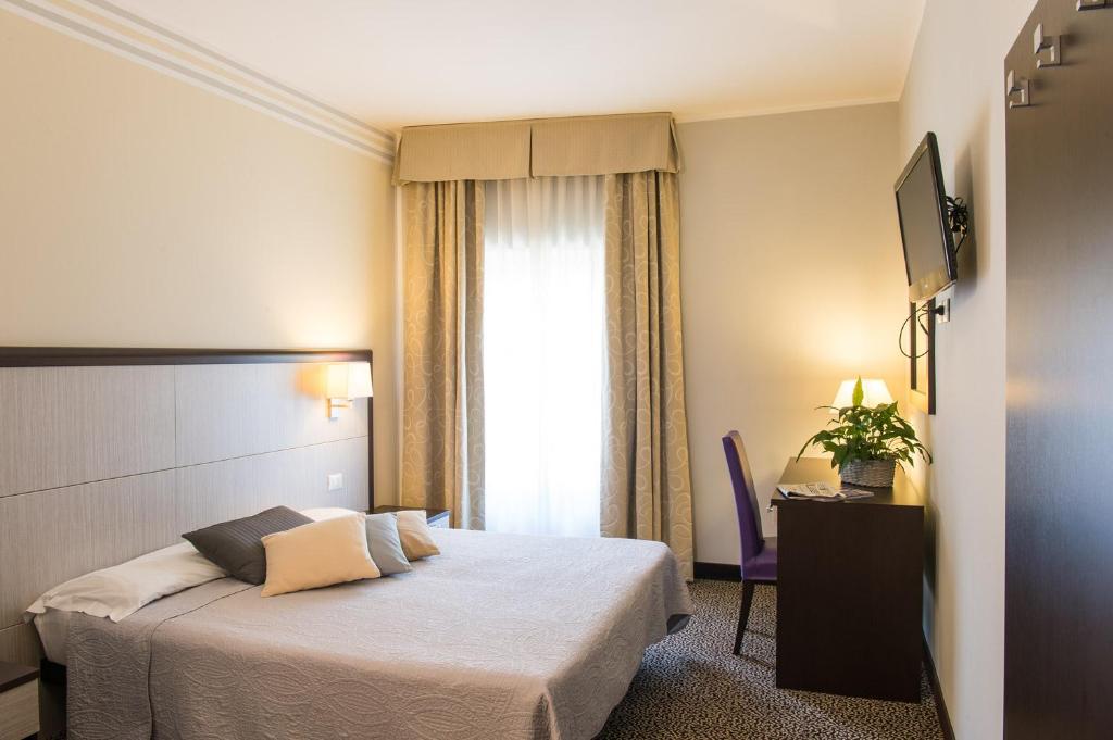 Una habitación de hotel con una cama y una ventana. en Hotel Alpi Resort, en Turín