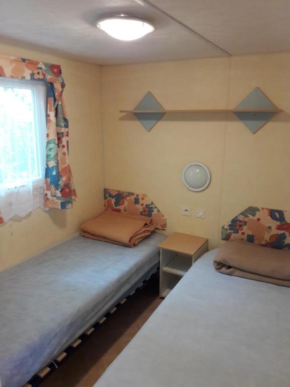 1 Schlafzimmer mit 2 Betten und einem Fenster in der Unterkunft Camping Maureillas in Maureillas