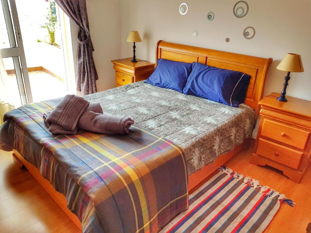 カニコにあるFalesia Apartment - Reis Magos Beachのベッドルーム1室(カラフルな毛布付きのベッド1台付)