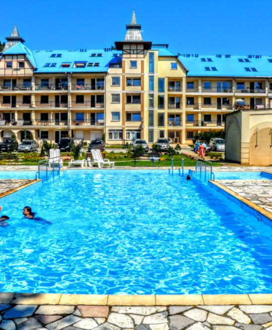 a large swimming pool in front of a large building at Blue Mare Apartamenty U Tomka in Łukęcin