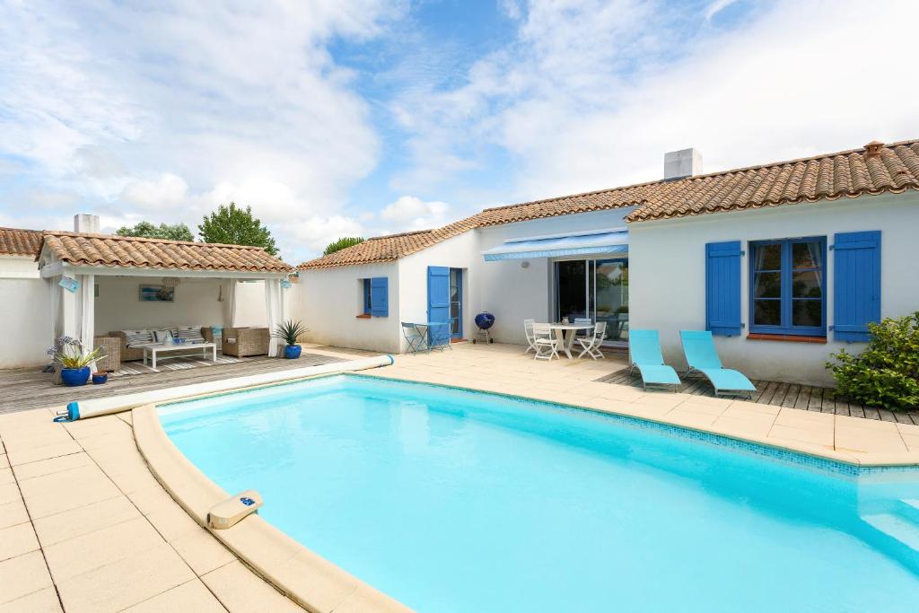 a swimming pool in front of a house at Madame Vacances Le Domaine de Vertmarines in Saint-Jean-de-Monts