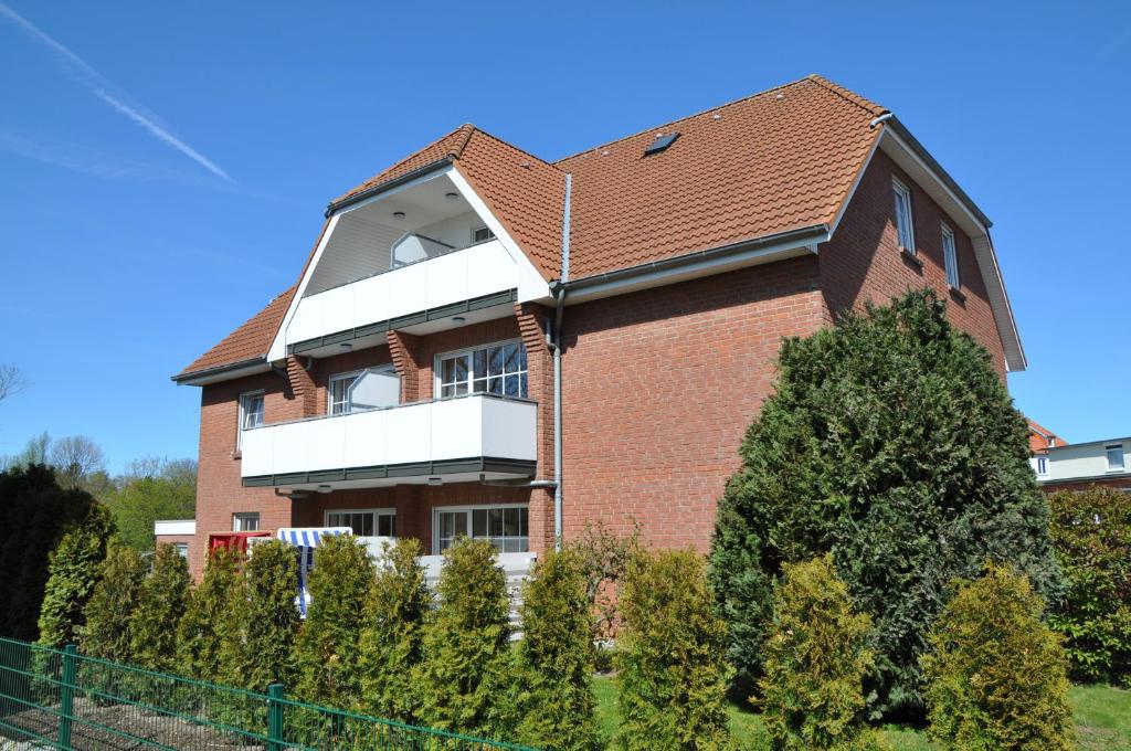 un gran edificio de ladrillo con un balcón blanco en Haus Antonie 1. Etage en Dahme