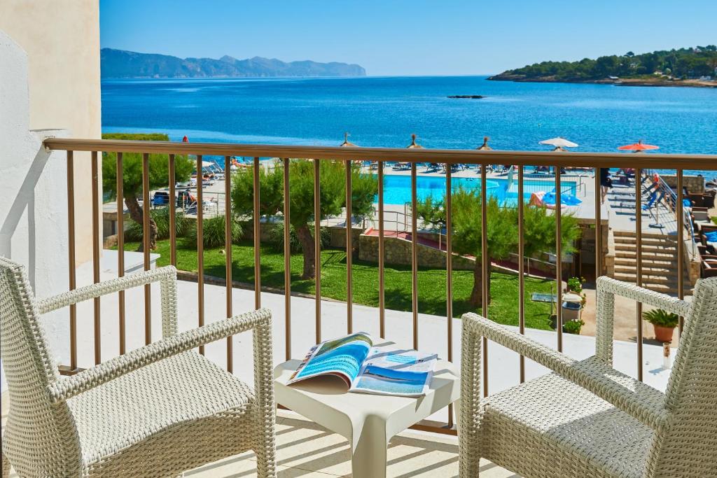 a balcony with chairs and a view of the ocean at Hotel Moré in Alcudia