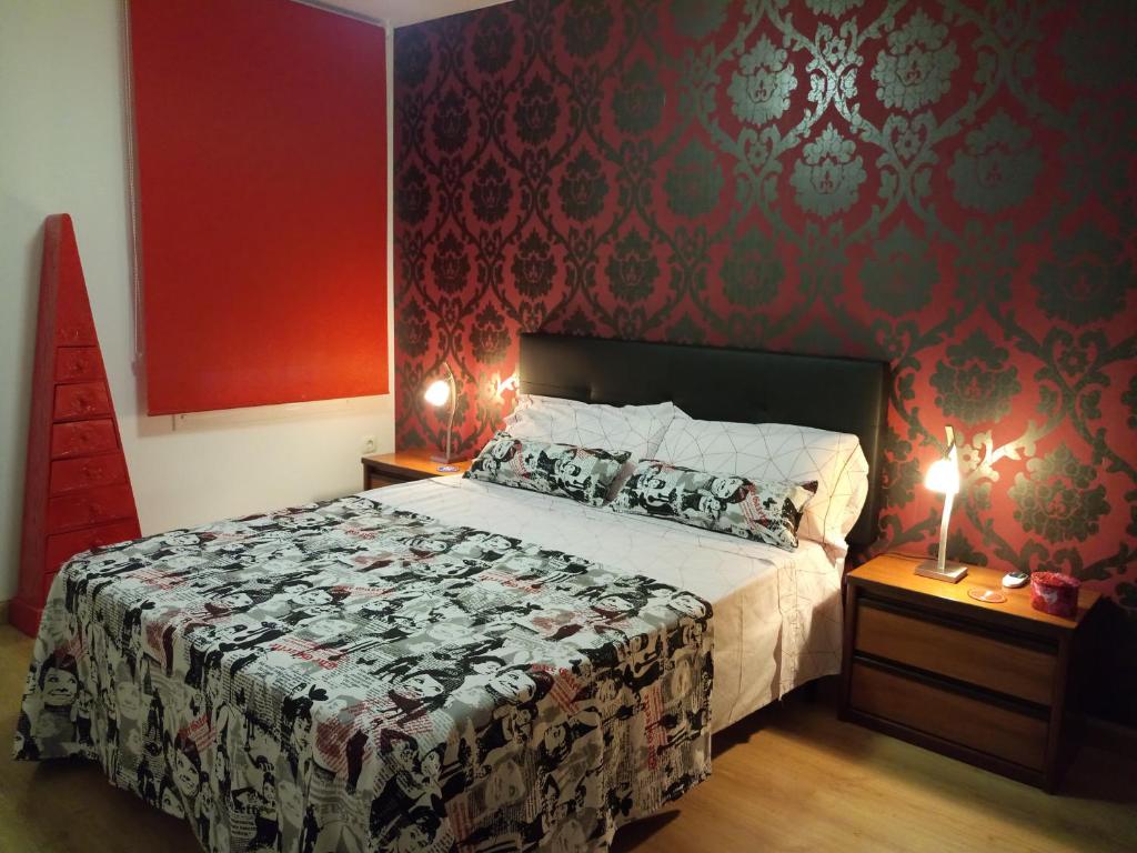 1 dormitorio con 1 cama grande y paredes rojas en Apartamento Estrella Rural, en Lumpiaque