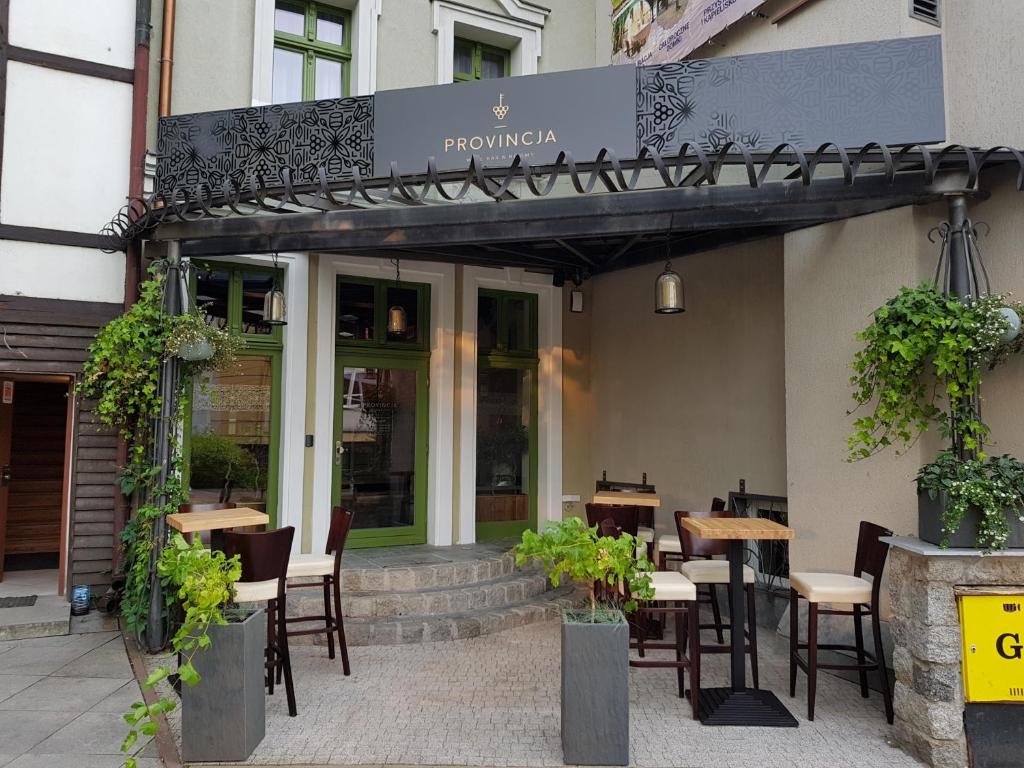 a restaurant with tables and chairs in front of a building at Provincja Winebar & Rooms in Olsztyn