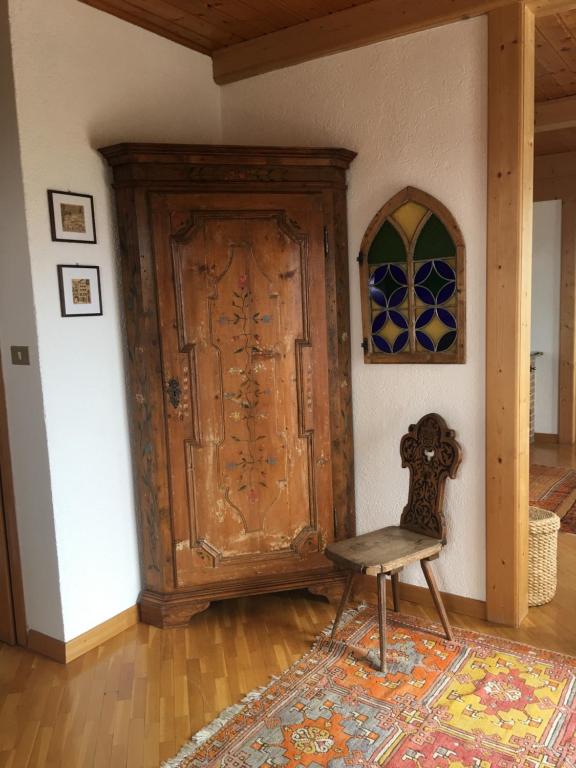 a chair in a room with a wooden door at Appartamento Klobenstein in Collalbo