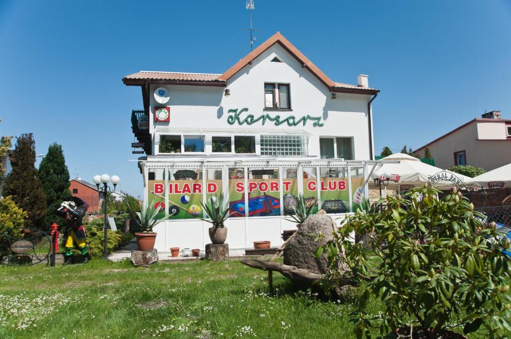 een wit huis met een bord dat de eilandsportclub leest bij Pokoje Gościnne Korsarz in Ustka