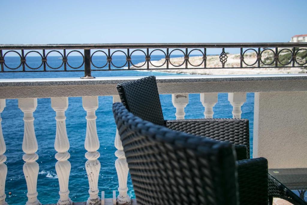 two chairs sitting on a balcony overlooking the ocean at Apartment Lorena in Sevid