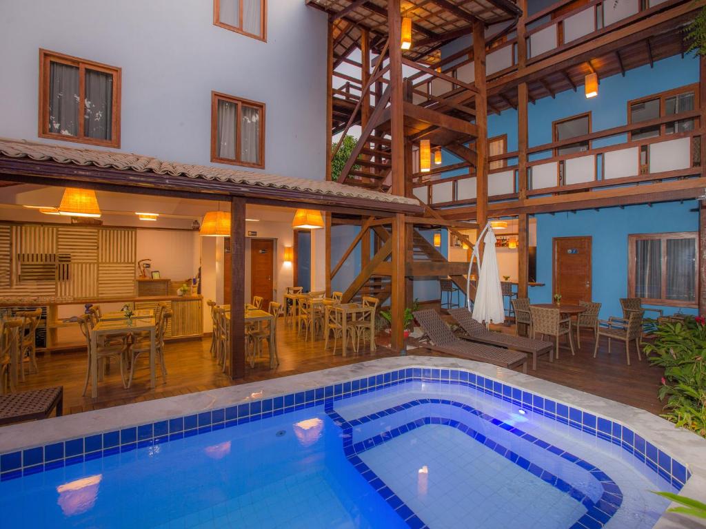 a house with a swimming pool and a restaurant at Pousada Paraíso do Forte in Praia do Forte