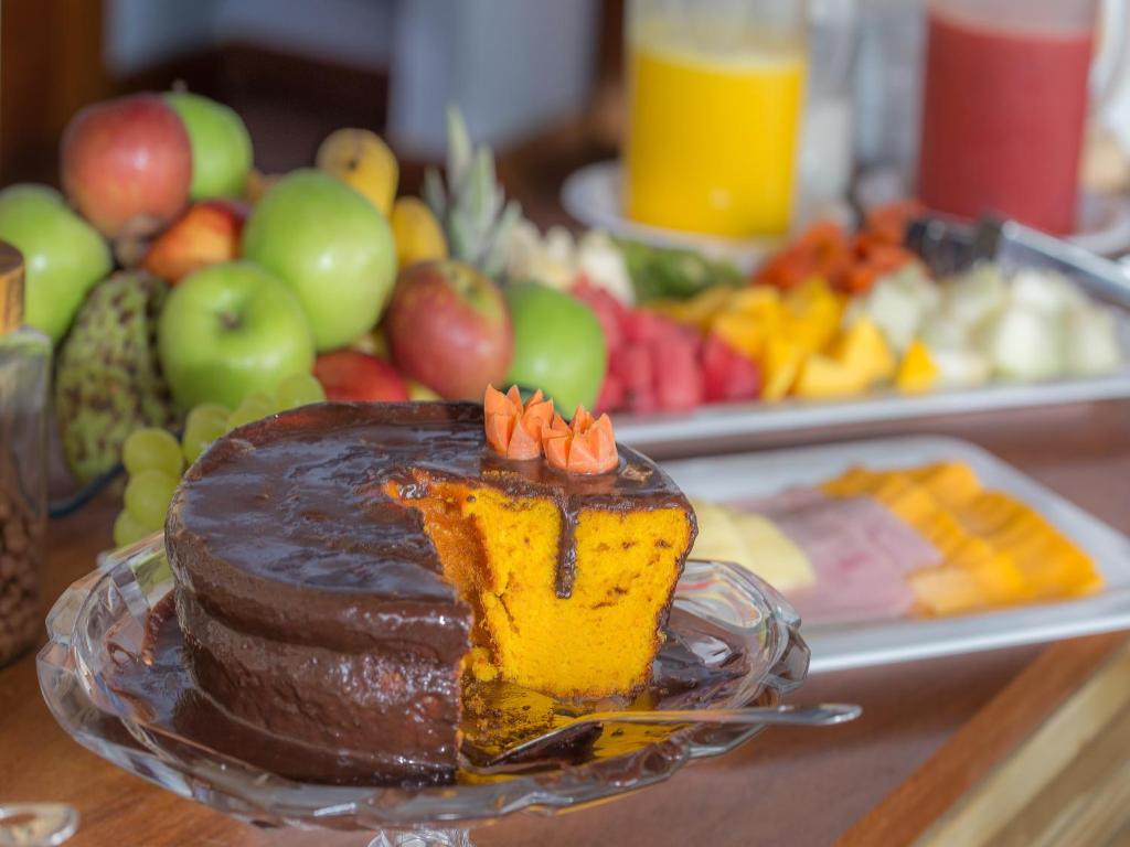a chocolate cake on a glass plate on a table at Pousada Paraíso do Forte in Praia do Forte