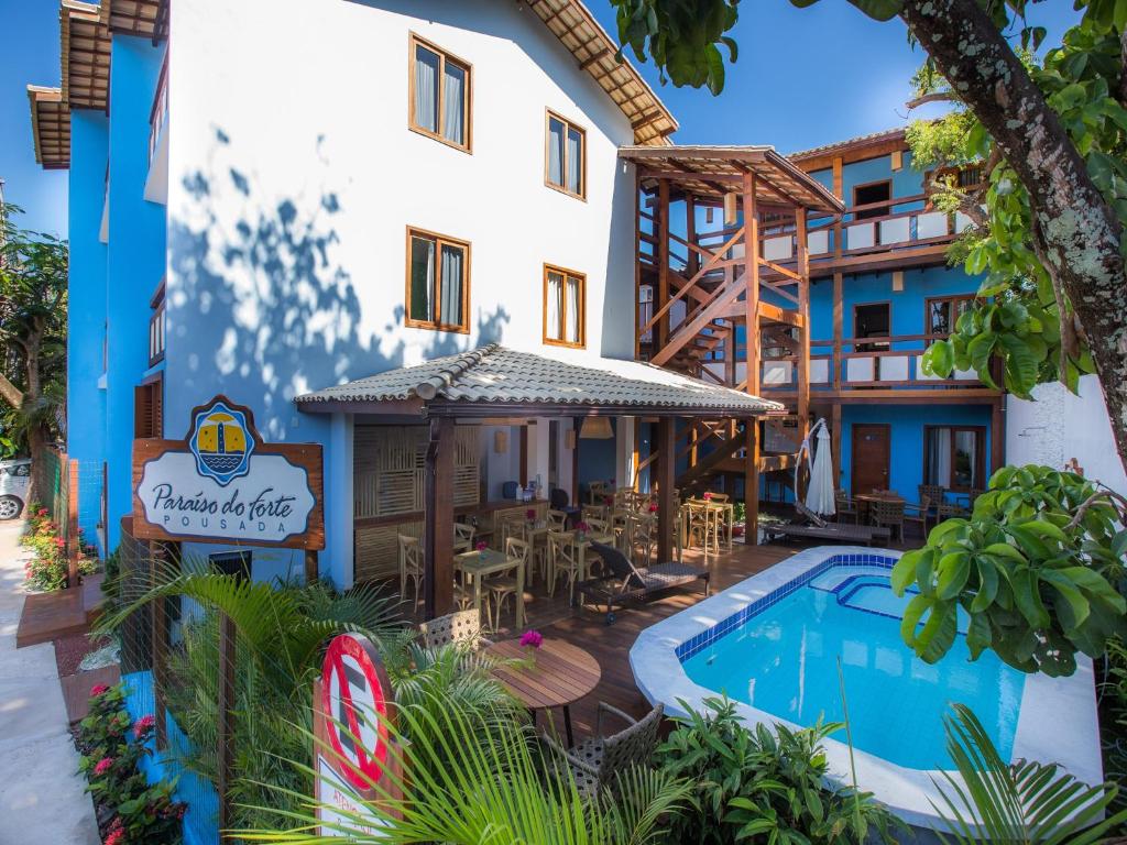 ein Hotel mit einem Pool vor einem Gebäude in der Unterkunft Pousada Paraíso do Forte in Praia do Forte
