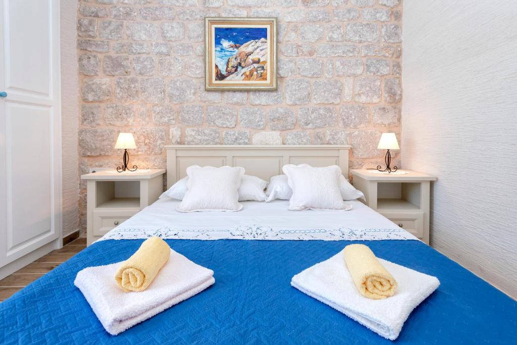 a bedroom with a blue bed with towels on it at Villa Riva in Jelsa