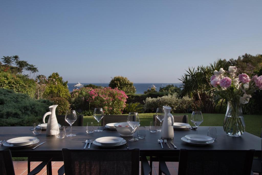 einen Tisch mit Weingläsern und eine Vase Blumen in der Unterkunft Monaco Country Park in Roquebrune-Cap-Martin