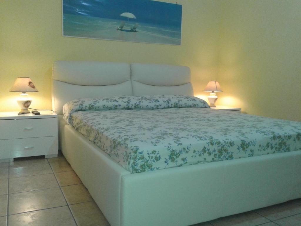 トッレ・ラピッロにあるVia Zanella Guesthouseのベッドルーム(白いベッド1台、ランプ2つ付)