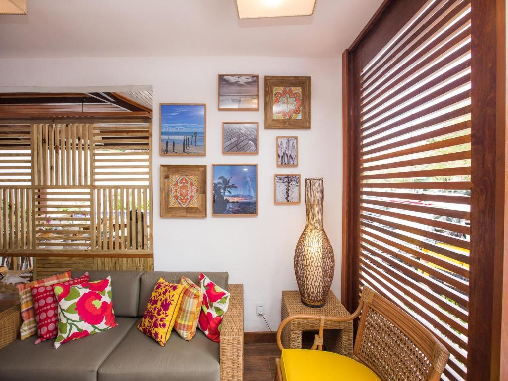 a living room with a couch and a vase at Pousada Paraíso do Forte in Praia do Forte
