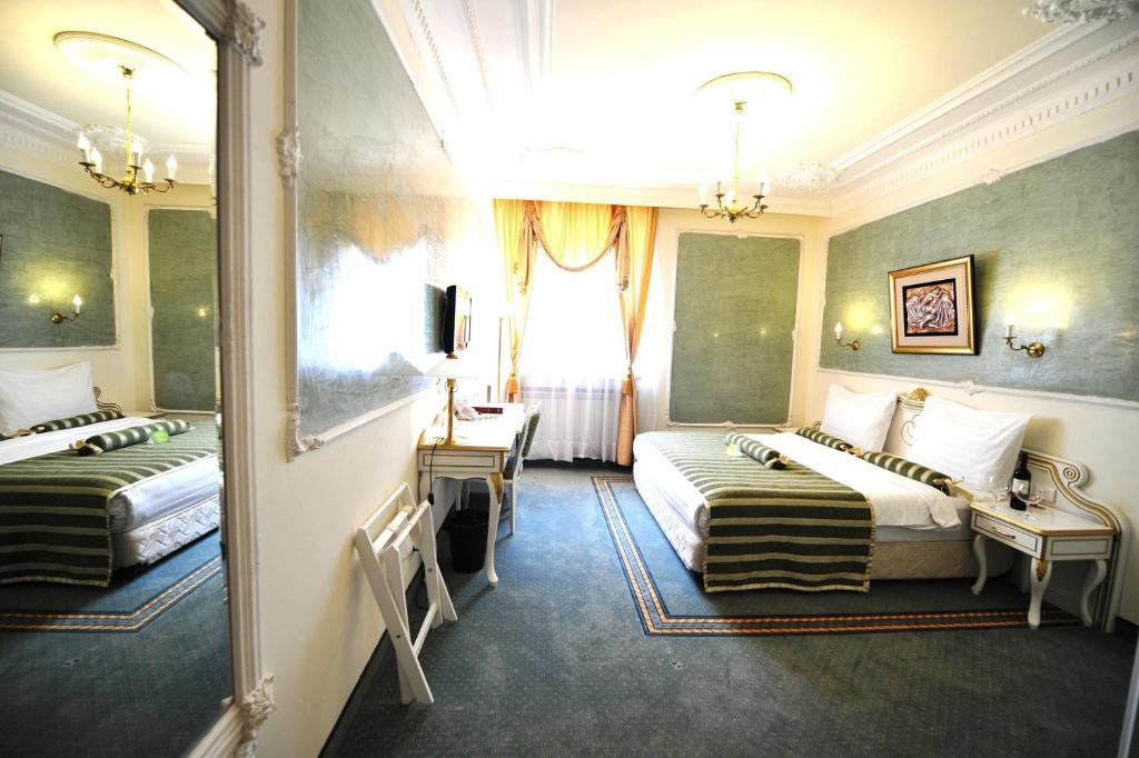 Postel nebo postele na pokoji v ubytování Queen's Astoria Design Hotel