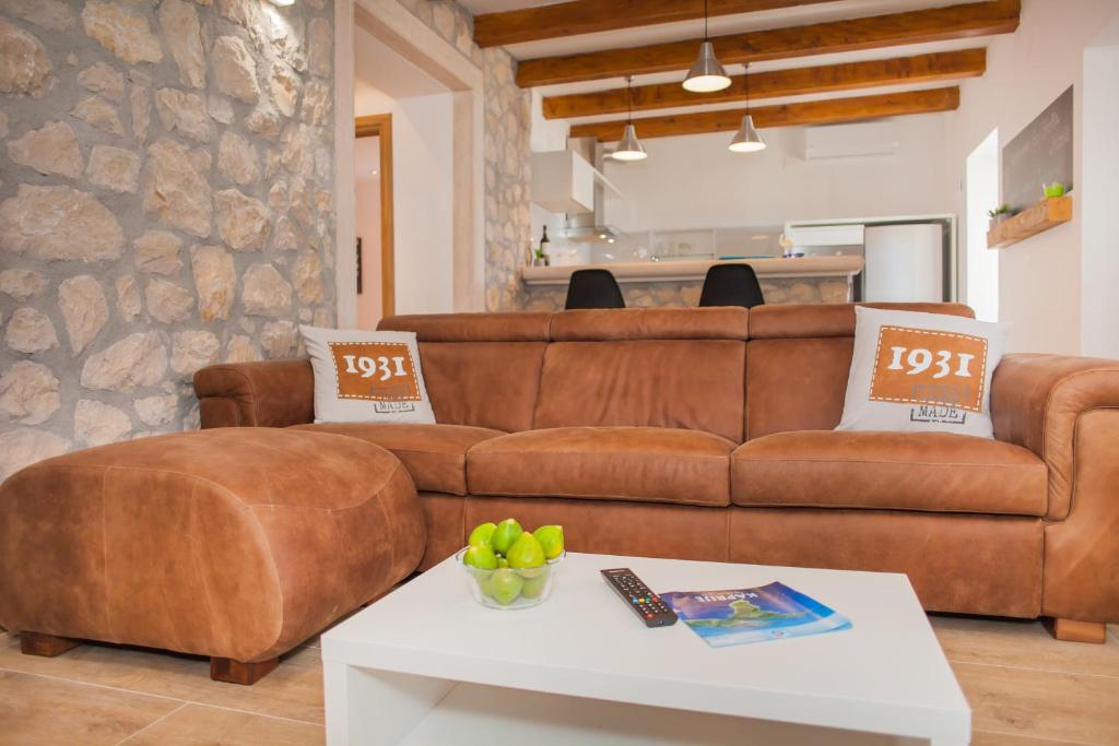 sala de estar con sofá marrón y mesa en Apartment Stella Maris, en Kaprije