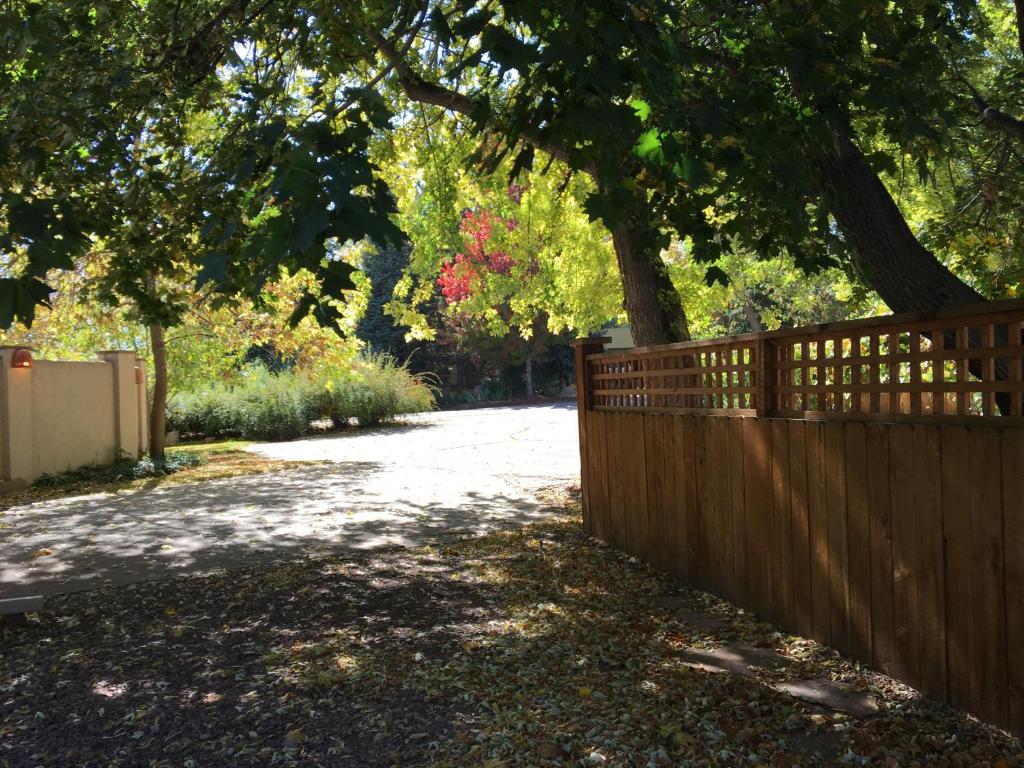 a fence next to a driveway with a tree at Like Home but Better! A Boulder Favorite!! in Boulder
