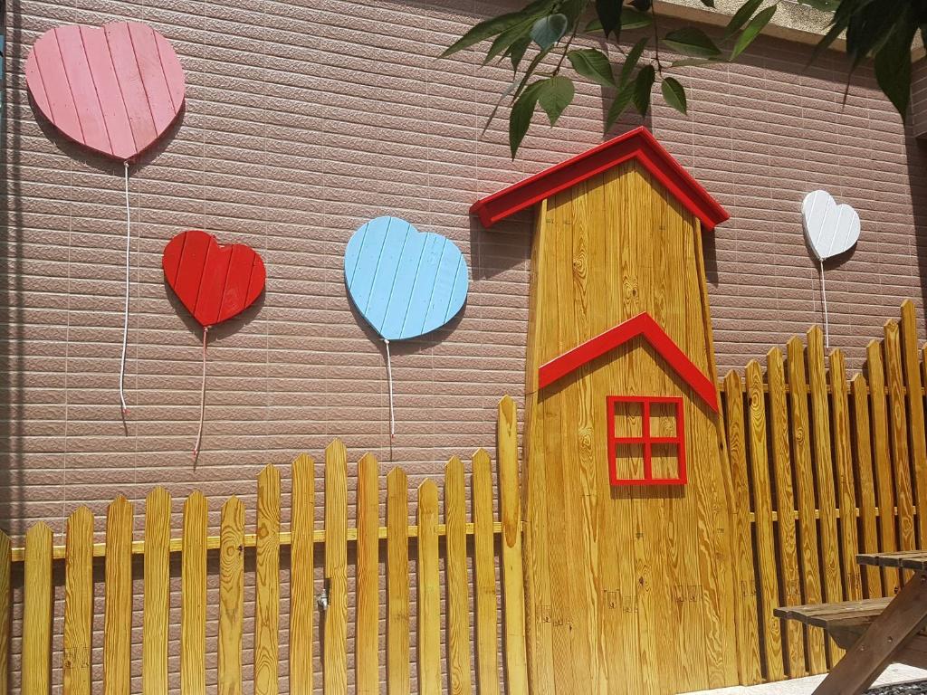 una pared con corazones y una casa pintada en ella en Moon Villa en Zhongpu