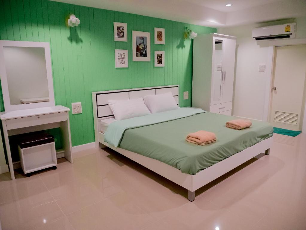 邦賢的住宿－UJ公寓酒店，绿色卧室配有带2条粉红色毛巾的床