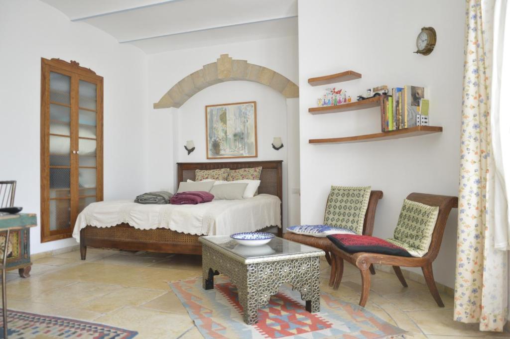 a bedroom with a bed and a table and chairs at Above The Spring in Jerusalem