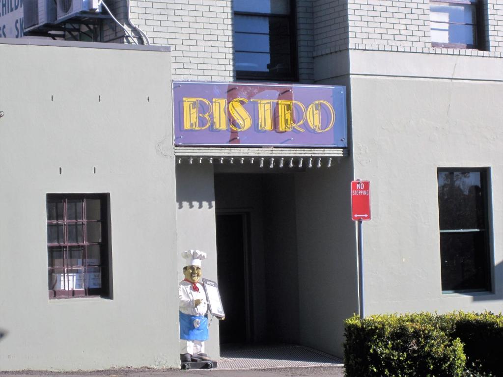 a person standing in the doorway of a building with a sign at Katoomba Hotel in Katoomba