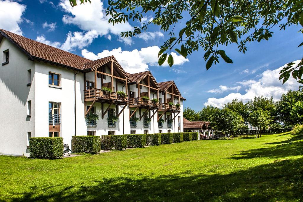 ein großes weißes Gebäude mit einem grünen Hof in der Unterkunft Hotel Restaurant Seegarten in Arbon